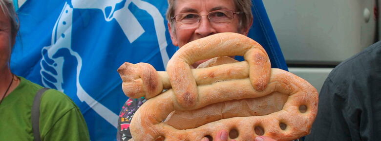 Teilnehmerin des Augsburger Friedensfestes hält einen gebackenen Panzer in der Hand, dessen Kanone verknotet ist Teilnehmerin des Augsburger Friedensfestes hält einen gebackenen Panzer in der Hand, dessen Kanone verknotet ist